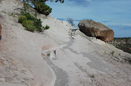 A narrow trail worn into pale volcanic rock at Tsankawi in Bandelier National Monument
